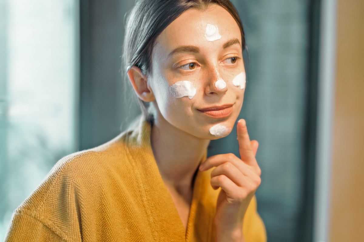 donna si passa la crema sul viso