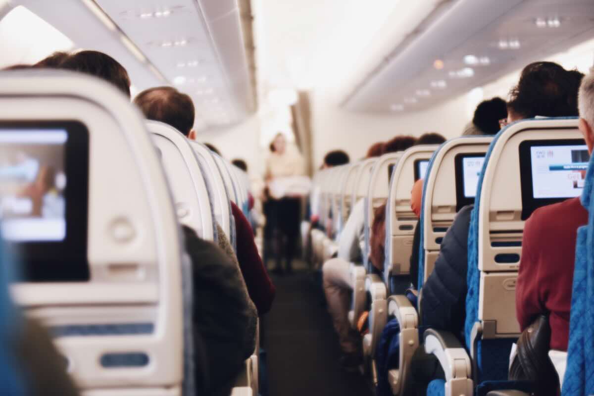 persone in aereo di spalle